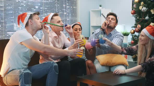 Best Friends Making Cheers and Blowing Party Whistle on Christmas Party