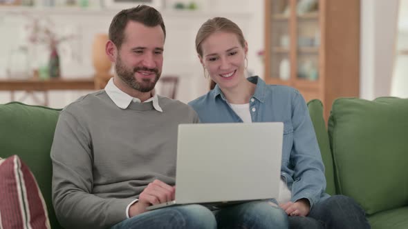 Happy Couple Doing Video Chat on Laptop at Home