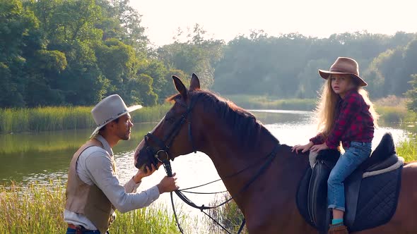 Cowboy and His Daughter on Horseback