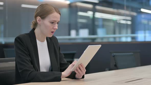 Businesswoman Reacting to Loss on Tablet at Work