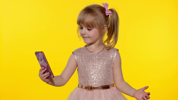 Child girl using smartphone, Portrait of blonde kid emotionally makes selfie on mobile phone