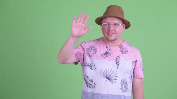 Happy Overweight Bearded Tourist Man Waving Hand