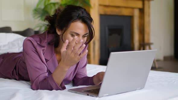 Middle Aged Woman in Front of a Laptop Monitor in Bed