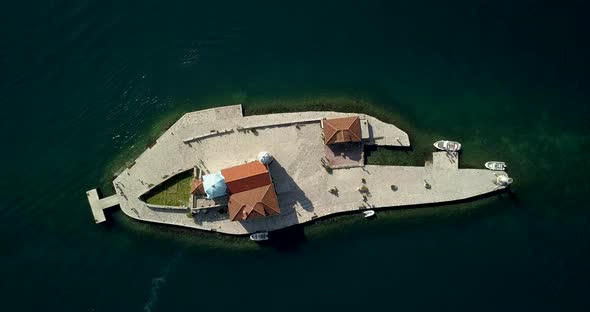 Our Lady of the Rocks, man made island with a church, in Montenegro. birds eye aerial view.