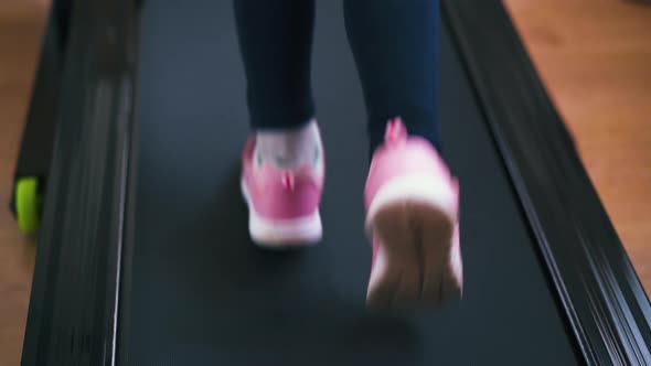 Active Girl in Pink Sneakers Runs on Athlete Track at Home