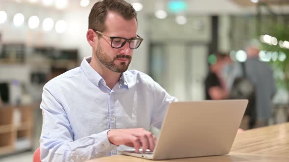 Hardworking Businessman Working on Laptop in Office 