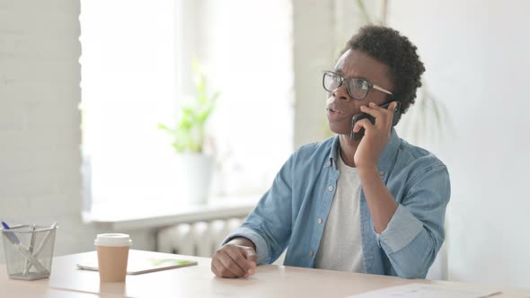 Angry Young African Man Talking on Phone