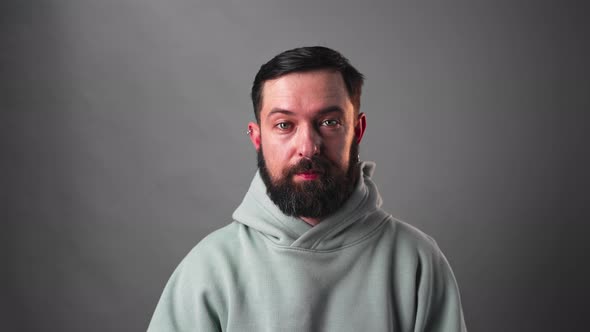 Slow Motion Portrait of Bearded Man Moving His Eyebrows on Grey Background