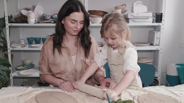 Portrait of Mother and Little Girl Shaping Clay Together