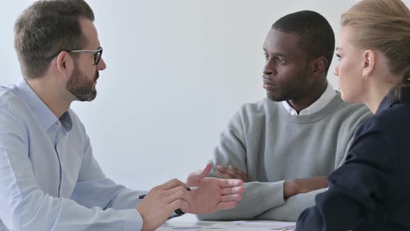 Serious Businessman Talking to Colleagues in Office