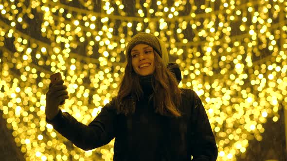 Portrait of a Happy Girl on a Evening Street Decorated with Christmas Lights