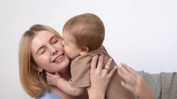 Young Mother Playing with Her Infant Baby Kissing Mom's Cheek Spending Time Together Slow Motion