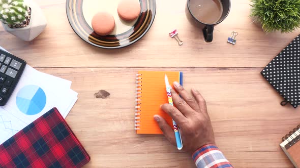 Top View of Man Hand on a Notepad on Office Desk