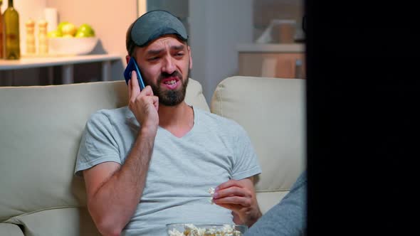 Tired Man with Sleep Mask Put Talking on Smartphone