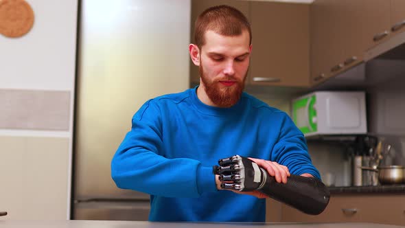 Young Man with Robotics Mechanical Modern Bionic Hand in Home