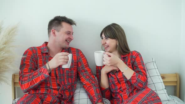 Happy Couple Drinking Tea in Bed in the Morning