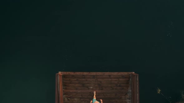 A Man is Jumping From a Pier Into the Water