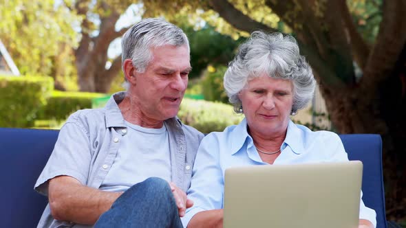 Happy senior couple using laptop 4k