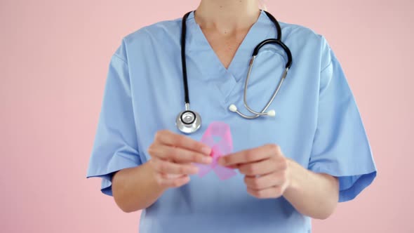 Nurse showing breast cancer awareness ribbon