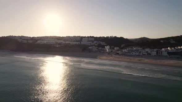 Salema beach against beautiful sunset sunbeam. Aerial of Algarve Atlantic Ocean