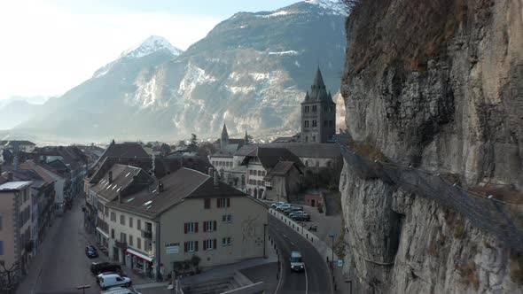 Aerial of beautiful old Church tower in an idyllic Swiss town located underneath mountain