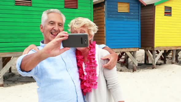 Senior couple taking a selfie on the beach