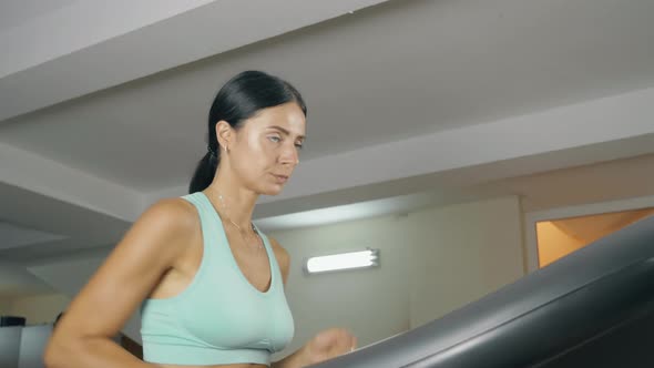 Young Girl Running on the Treadmill in the Fitness Room