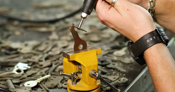 Locksmith in workshop makes new key, use grinding engraving machine