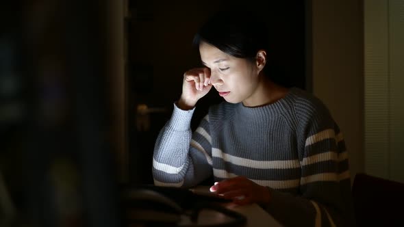 Woman using tablet computer at home in the night time