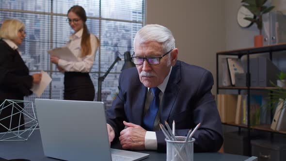 Senior Freelancer Concentrated Developing Project While Working Typing on Laptop Computer in Office