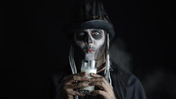 Creepy Man with Skeleton Makeup in Top-hat. Guy Looking at Camera, Drinks Milk From a Glass