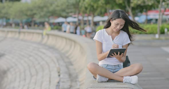 Woman Drawing on Tablet Computer Under Sunset