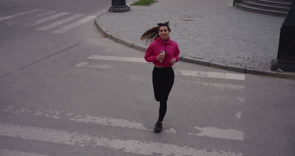 Sporty Woman Jogging in the City Crossing Road on a Zabra