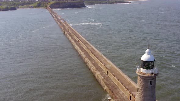 A Lighthouse and Breakwater at the Mouth of a Harbour