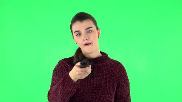 Woman with TV Remote in Her Hand, Switching on TV. Green Screen