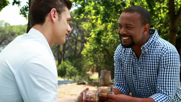 Male friends toasting beer mugs in outdoor restaurant 4k