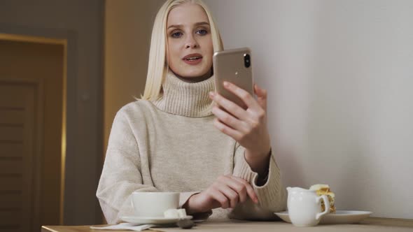 Caucasian Beautiful Young Female Siting at Cafe Terrace and Recording Voice Message on Smartphone