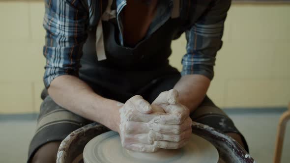 Skillful Young Potter Molding Ceramic Vase From Clay on Turning Throwing Wheel in Studio