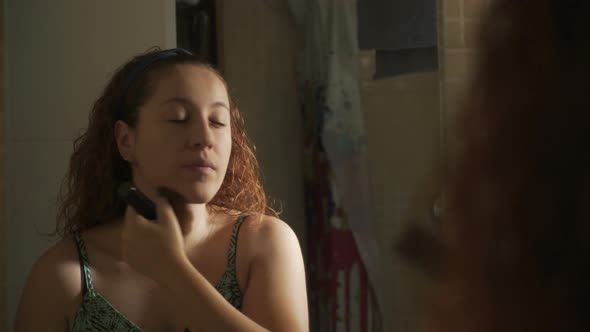 Redhead Woman Putting Makeup On In Front Of Mirror