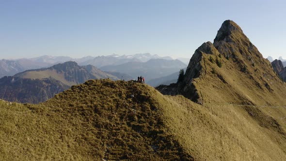 Low aerial orbiting hikers on summit "La Cape au Moine", Vaud - Switzerland