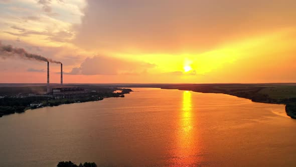 Amazing orange sunset over the river. Magic aerial view of evening sun among clouds.