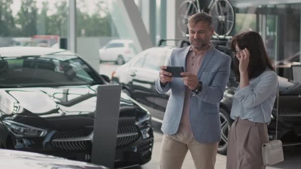 Slowmo of Man and Woman in Car Dealership