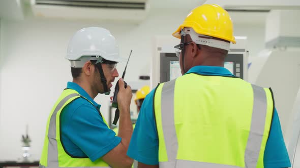 Group of interracial worker people wearing protective safety equipment helmet and glasses in factory