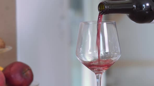 Pouring red wine on a glass in slow-motion