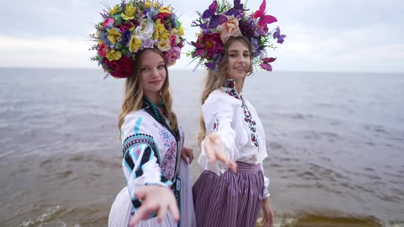 Two Beautiful Young Ukrainian Women in Traditional Head Wreathes and National Dresses Stretching