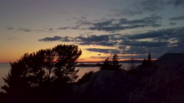 Reveal of Small Island in Lake just after Sunset, Drone Aerial Wide Dolly In. Fly Between Trees to s