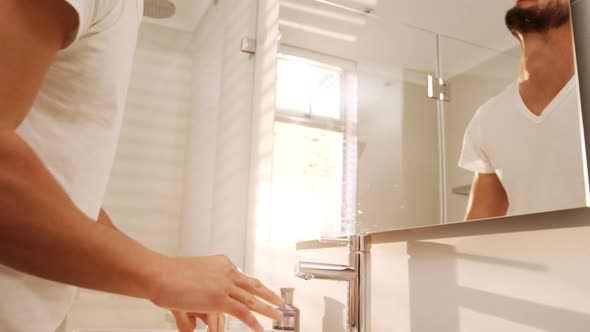 Man washing his face with a towel in bathroom