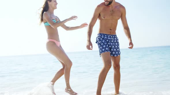 Man giving piggyback ride to woman at beach