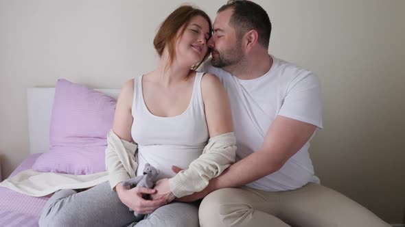 Pregnant Girl and Man in White T-shirts Sitting