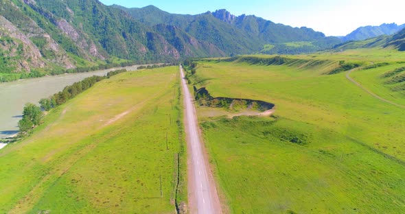 Aerial Rural Mountain Road and Meadow at Sunny Summer Morning